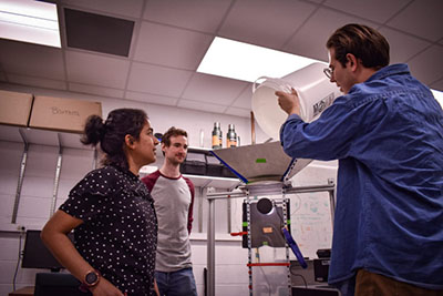 Dr. Bala Chandran and students, Mike Mayer and Brandon Surghigh, setting up an experiment that features flowing particles (see video above).