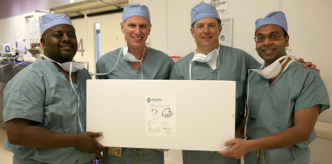 From left: Eugene Thomas, James Geiger, Greg Bowles and Shorya Awtar hold an unopened package with a FlexDex instrument inside as they stand outside of a University of Michigan Hospital surgery room where the instrument will be used for the first time in surgery.
