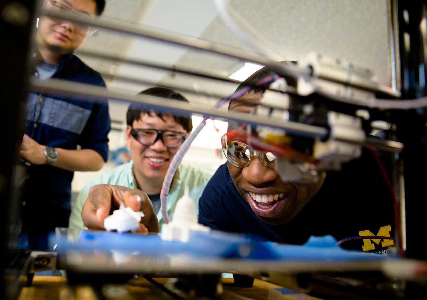 Molong Duon and Deokkyun Yoon, both mechanical engineering PhD students, and Chinedum Okwudire, associate professor in mechanical engineering, examine the effectiveness of their new, faster 3D printing algorithm. Credit: Evan Dougherty, Michigan Engineering