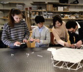 Serife Tol and students around a table assembling 3D printed materials
