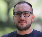 Jacinto Ulloa professional portrait, wearing glasses and a dark-colored shirt.