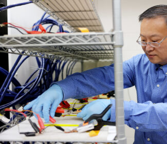 University of Michigan professor of Mechanical Engineering, Wei Lu, conducts research on batteries in a lab.