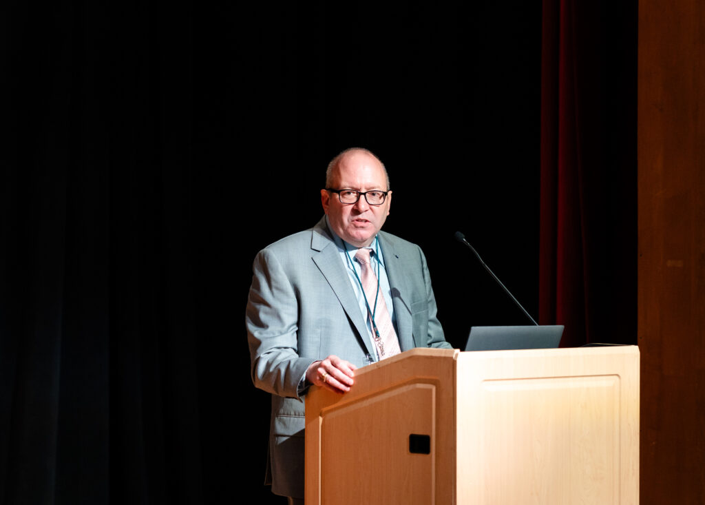 Dr. David Gorsich, Chief Scientist at the U.S. Army GVSC, stands at podium speaking.